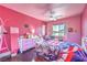 Bright bedroom featuring pink walls, ceiling fan, dresser, and bed with Statue of Liberty themed blanket at 261 Fairway Woods Dr, Las Vegas, NV 89148