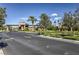 Community entrance featuring decorative stonework, lush landscaping, and well-maintained roadways at 261 Fairway Woods Dr, Las Vegas, NV 89148