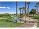 Scenic golf course view featuring lush greenery, palm trees, and a tranquil water feature on a sunny day at 261 Fairway Woods Dr, Las Vegas, NV 89148