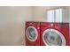 Modern laundry room with red washer and dryer machines at 261 Fairway Woods Dr, Las Vegas, NV 89148