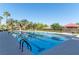 Beautiful community pool with clear blue water, palm trees, and lounge area under a bright sky at 261 Fairway Woods Dr, Las Vegas, NV 89148