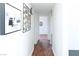Hallway with hardwood floors, white walls, and framed art pieces on display at 2616 Spear St, North Las Vegas, NV 89030