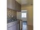 Kitchen with gray cabinets, granite countertops, mosaic backsplash, stainless steel sink and stainless dishwasher at 2616 Spear St, North Las Vegas, NV 89030