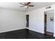 Spacious living room with dark-stained wood floors, a ceiling fan, and bright white walls at 2616 Spear St, North Las Vegas, NV 89030