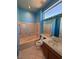 Bathroom boasts neutral paint, a bathtub with a shower, and a large mirror at 2695 Olivia Heights Ave, Henderson, NV 89052