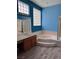 Bathroom with an integrated tub, shower, and wood-style flooring at 2695 Olivia Heights Ave, Henderson, NV 89052