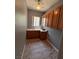 Functional laundry room with gray walls, tile flooring, and wooden cabinetry at 2695 Olivia Heights Ave, Henderson, NV 89052