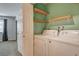 A laundry room equipped with a full-size washer and dryer set with convenient overhead shelving at 2785 Carnation Ln # 0, Henderson, NV 89074