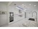 Gourmet kitchen featuring white cabinets, stainless steel appliances and a granite-topped kitchen island at 2851 Queens Courtyard Dr, Las Vegas, NV 89109