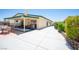Wide view of the backyard with a covered patio, lush greenery, and a spacious concrete area at 3484 Anthony Dr, Las Vegas, NV 89121