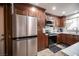 Renovated kitchen features stainless steel fridge and appliances complimented by warm wood cabinets at 3484 Anthony Dr, Las Vegas, NV 89121