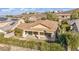 Aerial view of a backyard featuring a covered patio, privacy landscaping, and red tile roof at 37 Stonemark Dr, Henderson, NV 89052