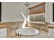 Bathroom features a soaking tub under a window and neutral tile at 37 Stonemark Dr, Henderson, NV 89052