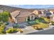 Beautiful home with a well-manicured lawn, desert landscaping, and a spacious driveway leading to the garage at 37 Stonemark Dr, Henderson, NV 89052