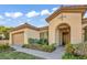 Inviting single-story home featuring a Mediterranean-style facade, arched entrance and manicured landscaping at 37 Stonemark Dr, Henderson, NV 89052