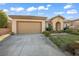 Charming single-story home featuring a tan exterior, two-car garage, and well-manicured landscaping at 37 Stonemark Dr, Henderson, NV 89052