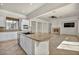 Open kitchen with granite countertop island flowing into a spacious living area with a fireplace at 37 Stonemark Dr, Henderson, NV 89052
