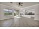 Open-concept living room featuring tile floors, a ceiling fan, and a seamless transition to the adjacent kitchen with white cabinetry at 37 Stonemark Dr, Henderson, NV 89052