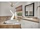 Beautiful bathroom with white cabinetry, a soaking tub, and a large window at 37 Stonemark Dr, Henderson, NV 89052