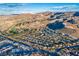 Expansive aerial view showcasing a residential community nestled amidst mountains and trees, offering a serene and picturesque living environment at 387 Solitude Peak Ln, Henderson, NV 89012