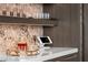 Modern bar area with white countertop, marble backsplash, decorative glassware and decor at 387 Solitude Peak Ln, Henderson, NV 89012