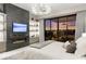 Modern bedroom with a fireplace, custom shelving, and a large window showcasing the sunset view at 387 Solitude Peak Ln, Henderson, NV 89012