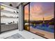 Stylish bedroom with a view of the swimming pool and a custom shelving unit with decorative items at 387 Solitude Peak Ln, Henderson, NV 89012