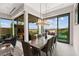 Spacious dining room with a wood table, modern chandelier, and sliding glass doors to a pool area at 387 Solitude Peak Ln, Henderson, NV 89012