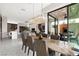 Open-concept dining room with contemporary chandelier and expansive views, with outdoor lounge at 387 Solitude Peak Ln, Henderson, NV 89012