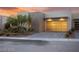 Contemporary home with a unique glass garage door, desert landscaping, and a clean, modern aesthetic at 387 Solitude Peak Ln, Henderson, NV 89012