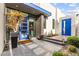 Contemporary home featuring a bright blue front door, lush desert landscaping, and a welcoming entryway ambiance at 387 Solitude Peak Ln, Henderson, NV 89012