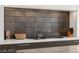 Cooktop featuring a sleek countertops and a stylish textured backsplash at 387 Solitude Peak Ln, Henderson, NV 89012