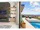 Open living room with a fireplace and view to outdoor pool and seating area at 387 Solitude Peak Ln, Henderson, NV 89012