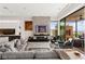 Spacious living room with a modern fireplace and open access to the kitchen at 387 Solitude Peak Ln, Henderson, NV 89012