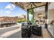 Covered patio with outdoor dining area overlooking a pool and landscaped hillside with city views at 387 Solitude Peak Ln, Henderson, NV 89012
