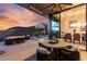 Elegant outdoor patio with dining and seating areas, offering stunning sunset views and access to the pool at 387 Solitude Peak Ln, Henderson, NV 89012