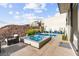 Modern outdoor space with a pool, spa, and patio offering stunning views of the hillside and neighborhood at 387 Solitude Peak Ln, Henderson, NV 89012