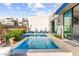 Modern pool design with blue accents, an outdoor shower, and elegant landscaping at 387 Solitude Peak Ln, Henderson, NV 89012