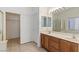Well-lit bathroom features a double vanity, large mirror, and tile flooring at 4043 Lilac Creek Ct, Las Vegas, NV 89122
