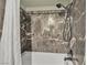Close-up of a tile shower with brushed bronze shower head at 4272 Sheppard Dr, Las Vegas, NV 89121