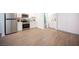 Bright living area with wood-look flooring, stainless steel kitchen appliances, and a view into the bathroom at 4600 University Center Dr # 72, Las Vegas, NV 89119