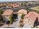 Aerial view showcasing three homes with long driveways, desert landscaping, and tile roofs at 5049 Running Rapids Ave, Las Vegas, NV 89130