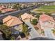 Aerial view of multiple homes with tile roofs, long driveways, desert landscaping, and mountain views at 5049 Running Rapids Ave, Las Vegas, NV 89130
