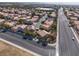 Wide aerial shot showcasing a neighborhood with similar homes, mature trees, and a multi-lane road for easy commuting at 5049 Running Rapids Ave, Las Vegas, NV 89130