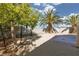 The backyard is spacious and includes desert landscaping, a concrete patio, and mature palm trees at 5049 Running Rapids Ave, Las Vegas, NV 89130