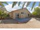 View of the spacious backyard featuring a patio, desert landscaping, and a stucco exterior at 5049 Running Rapids Ave, Las Vegas, NV 89130