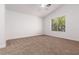 A bright bedroom with carpeted floors and a window overlooking greenery at 5049 Running Rapids Ave, Las Vegas, NV 89130