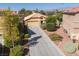 Aerial shot of home featuring a long driveway, desert landscaping, and a two car garage at 5049 Running Rapids Ave, Las Vegas, NV 89130