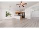 Open-concept living area with wood-look floors, ceiling fan, and kitchen featuring stainless steel appliances at 5049 Running Rapids Ave, Las Vegas, NV 89130
