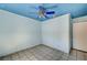 Small bedroom with blue walls and ceiling, tile floors, and a modern ceiling fan at 5121 Gains Mill St, Las Vegas, NV 89122